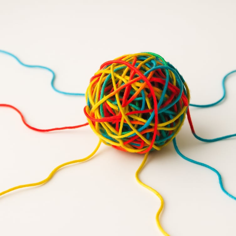 A tangled ball of yarn with multiple threads, representing the complexity of custom API development.